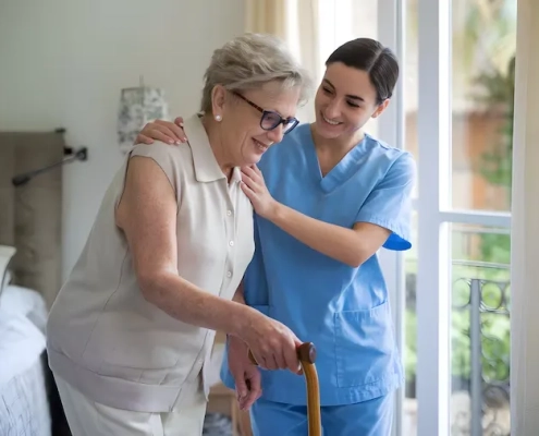 Cuidadora a domicilio ayudando a una mujer mayor