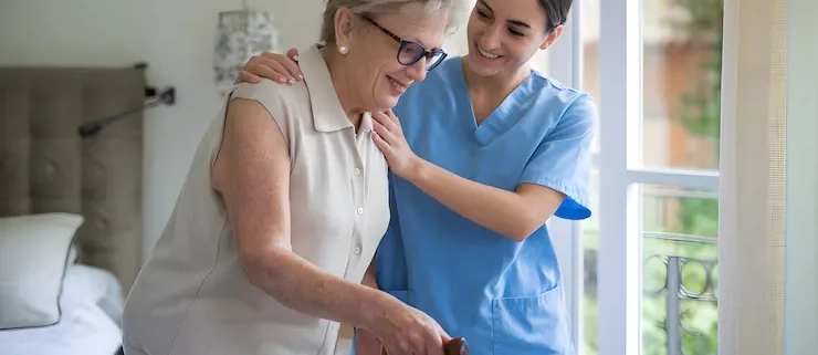 Cuidadora a domicilio ayudando a una mujer mayor