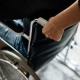 Hombre agarrando por el asa una silla de ruedas